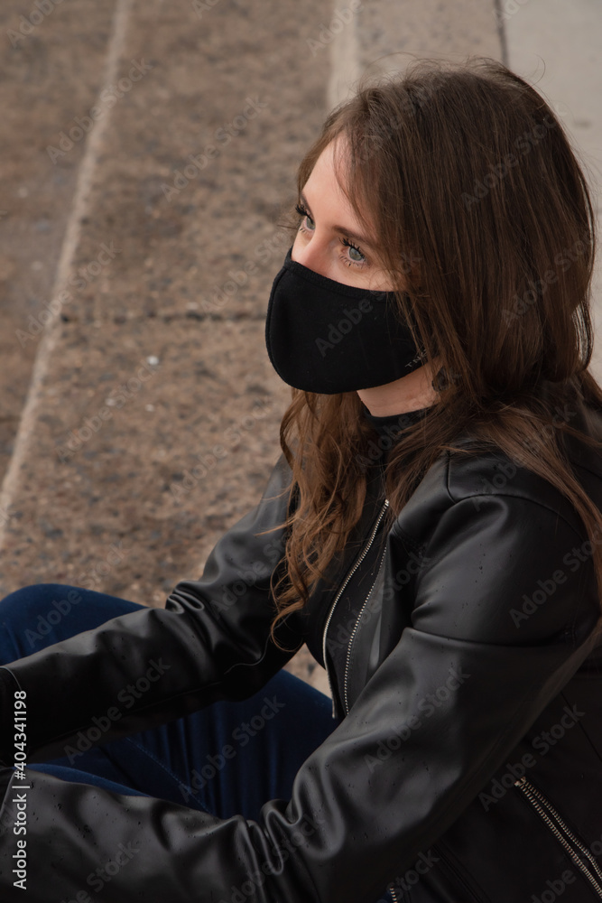 Beautiful woman in the city with black face mask for protection from contagion by Coronavirus, Covid-19 Beautiful woman in the city with black face mask for protection from contagion by Coronavirus, Covid-19