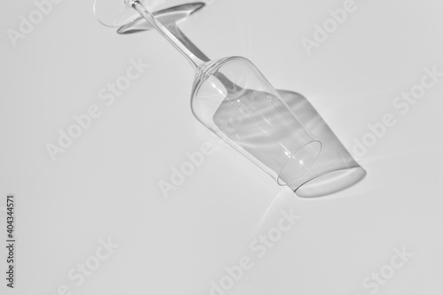 Champagne glass on white surface. Glass with shadow on white table.