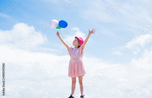 international childrens day. happy childhood. little child with balloons. Entertainment birthday concept. freedom. child having party and dancing with balloons in hands. kid having fun