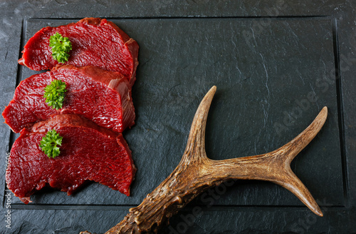 Fotografiet Raw steak meat from roe deer on the bridlic  chopping board