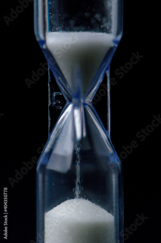 hourglass with sand on black background 