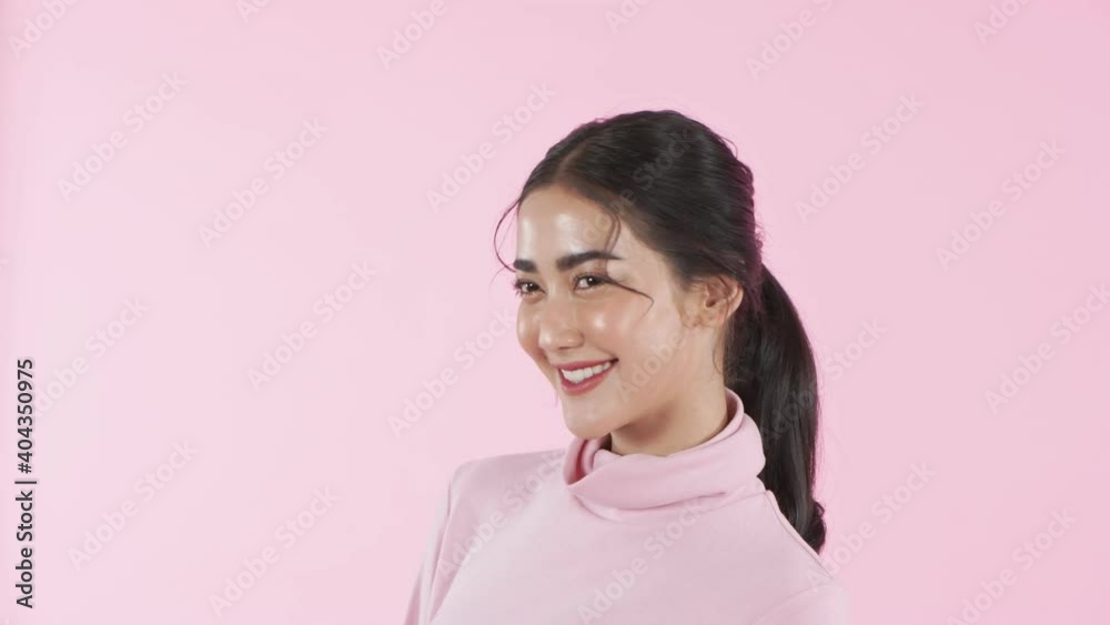 Beauty concept of 4k Resolution. Young Asian woman smiling charmingly on a pink background. Beauty concept of 4k Resolution. Young Asian woman smiling charmingly on a pink background.