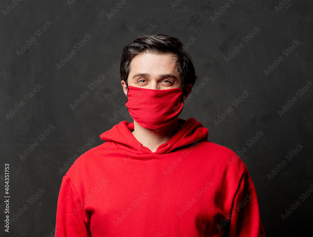 guy in red sweatshirt and face mask on dark background guy in red sweatshirt and face mask on dark background
