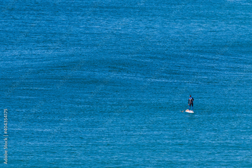 Lone paddleboarder on an empty ocean