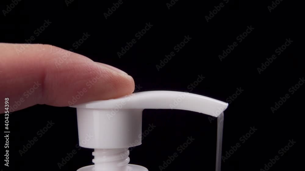 Man squeezes a gel sanitizer from a dispenser an antiseptic disinfector on a black background. Macro shot Man squeezes a gel sanitizer from a dispenser an antiseptic disinfector on a black background. Macro shot
