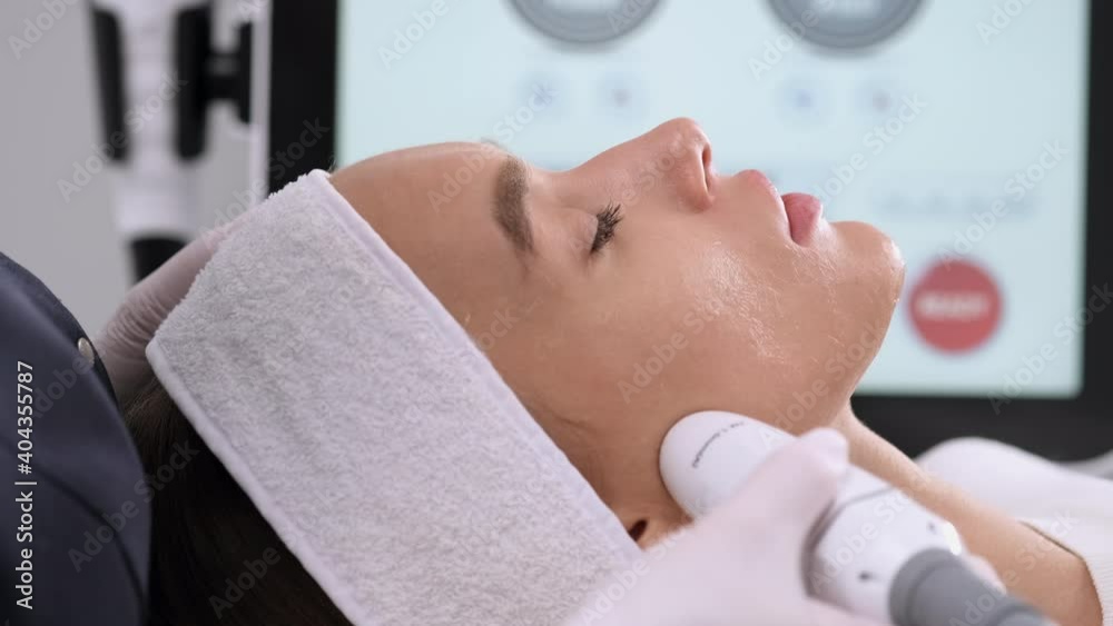 Apparatus cosmetology. Facelift device in beautician hand. Faceskin renovation. Non-surgical face lifting in beauty clinic. Apparatus cosmetology. Facelift device in beautician hand. Faceskin renovation. Non-surgical face lifting in beauty clinic.