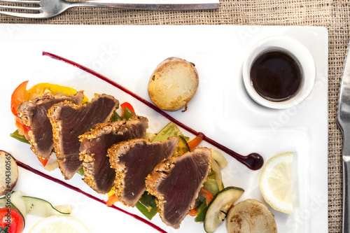 Top view of grilled tuna slices with sauces