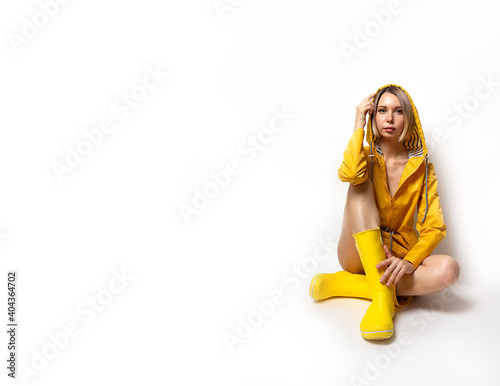 Tableau sur toile Horizontal banner with young woman in illuminating yellow slicker and rubber boots