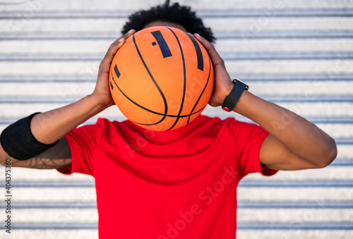 Afro athlete man holding a basketball ball outdoors. © Mego-studio