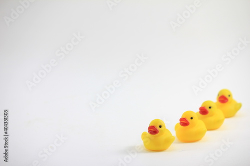 Billede på lærred Close-up Of Yellow Rubber Ducks Over White Background