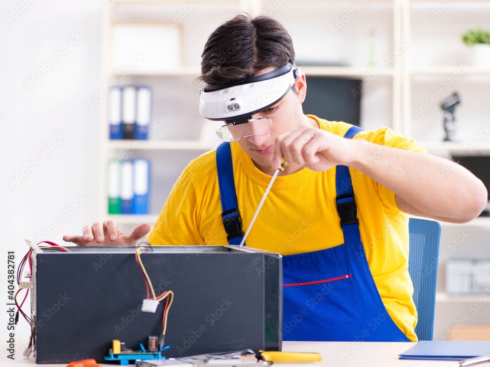 Computer repair technician repairing hardware Computer repair technician repairing hardware