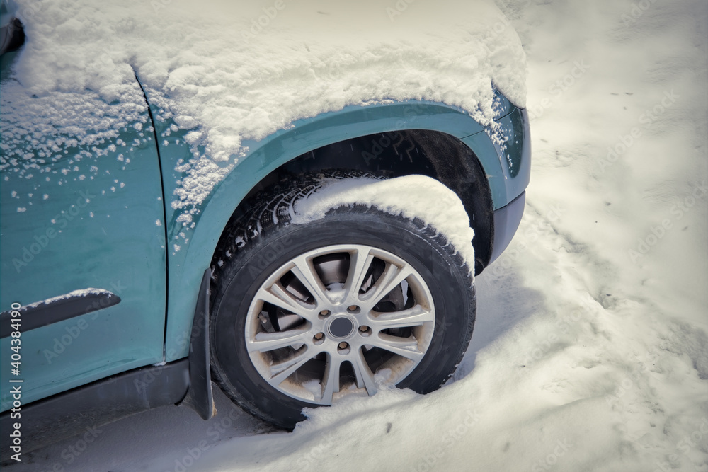 A car covered with a thick layer of snow. Close-up.
