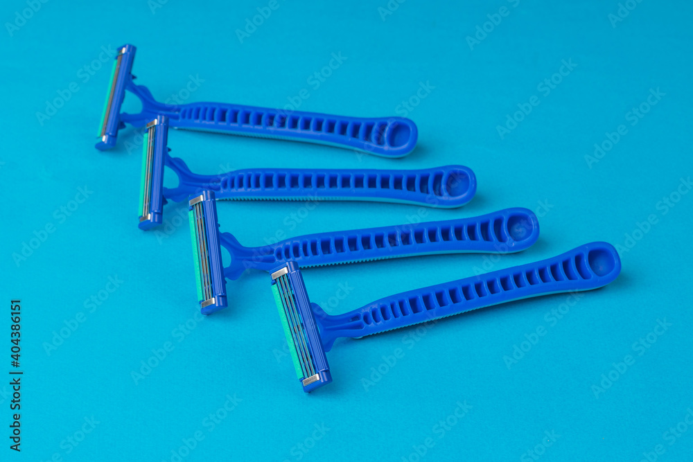 A set of blue disposable razors on a blue background. Tools for facial care. A set of blue disposable razors on a blue background. Tools for facial care.