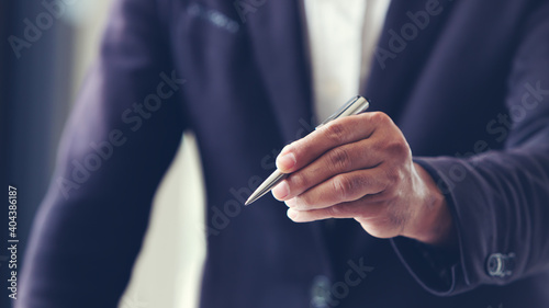close up of a businessman hand holding a ball point pen  