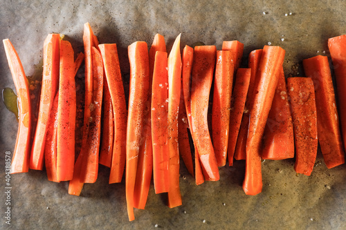 Sliced carrots on baking paper with sea salt and oil.
