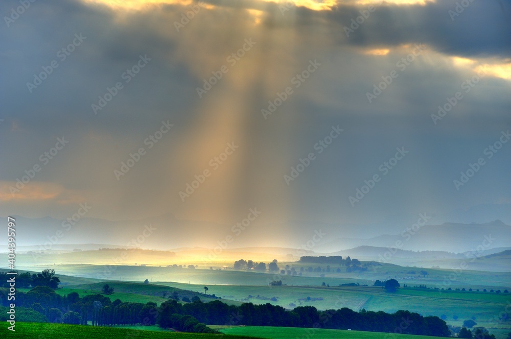 SUNBEAMS break through a stormcell passing over farmlands in the foothills of the Drakensberg, Kwazulu Natal, South Africa