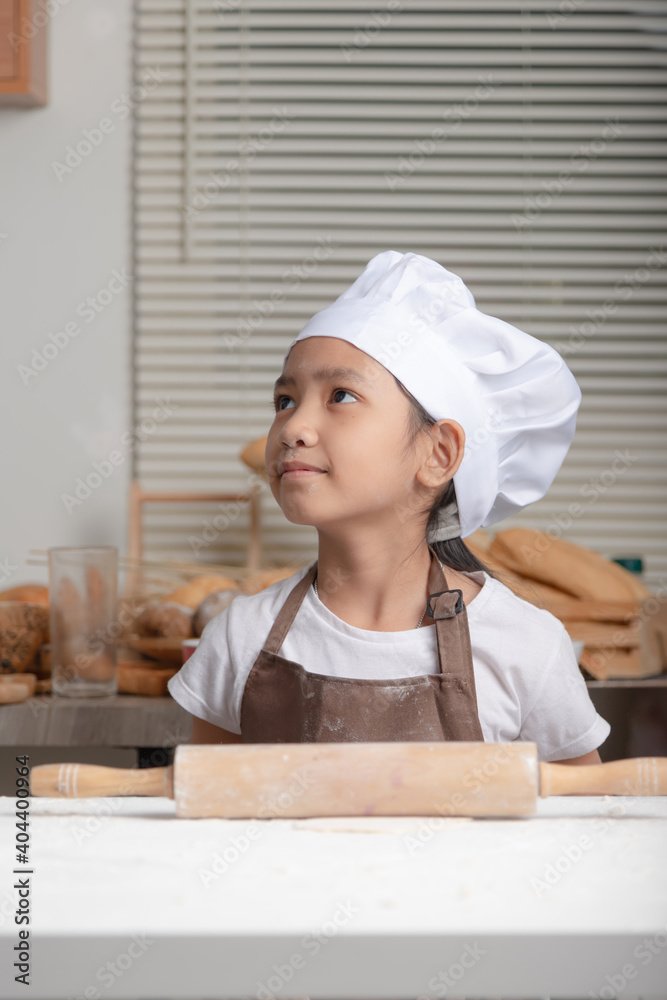 An Asian little girl wears a white chef hat An Asian little girl wears a white chef hat