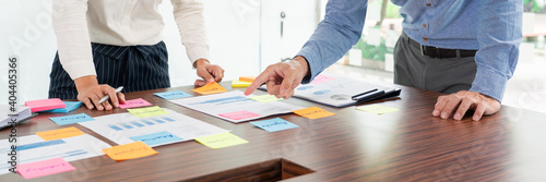 Creative group of business people brainstorming use sticky notes picking to share idea on table decision Choosing Concept for developing plan in business conference room.