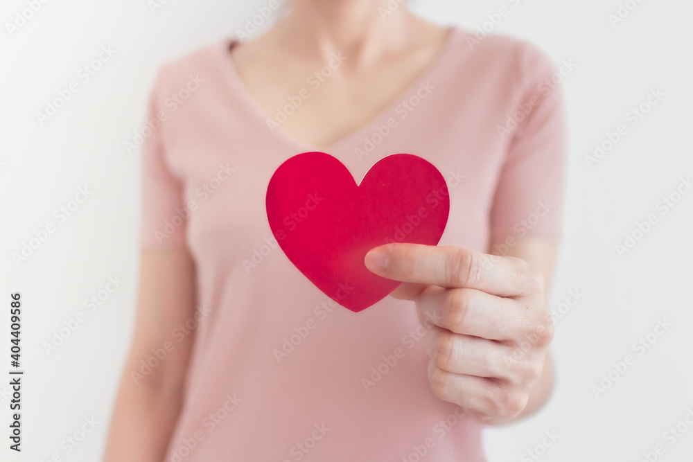 Woman in pink dress shows heart shape in the concept of love and valentine. Woman in pink dress shows heart shape in the concept of love and valentine.