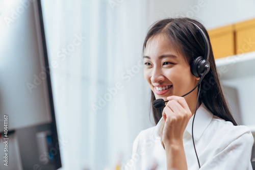 Asian business woman wear headset and working on telemarketing with online customer support.