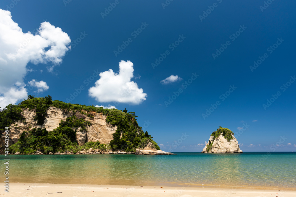 Sunny day at the beautiful Tsukigahama beach with its crystal clear waters, blue sky and rocks in the background composing the seascape. Iriomote Island.