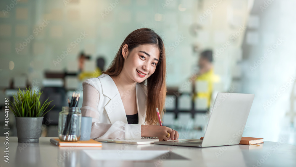 Smiling asian business woman sitting in a modern office. Smiling asian business woman sitting in a modern office.