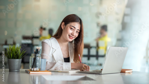 Smiling asian business woman sitting in a modern office.
