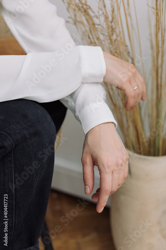 Hands of woman in white blouse in modern interior. Beige colors  lifestyle concept.