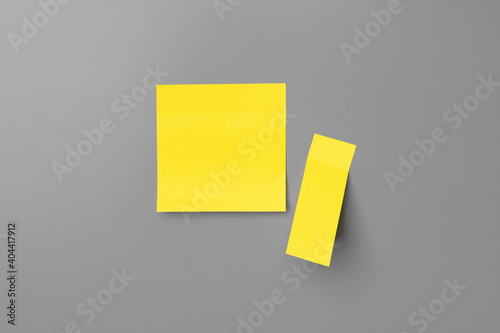 Yellow adhesive notes on gray background close up