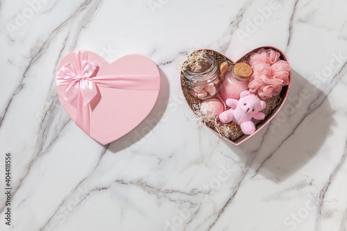 Top view of pink colored heart shaped gift boxes with homemade bath supplies, marshmallow sweets