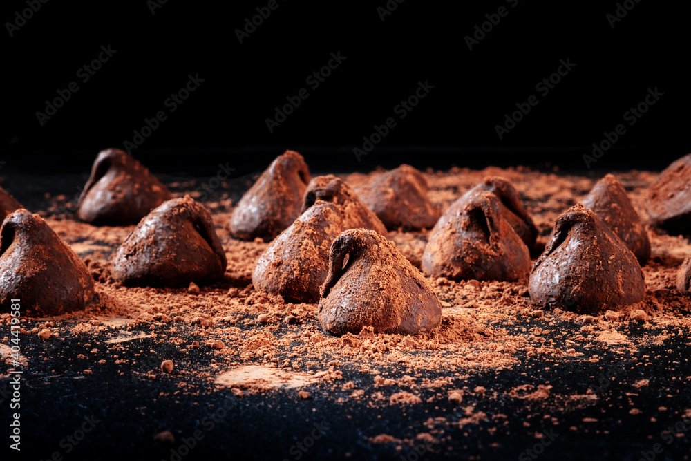 Fototapeta premium Chocolate truffles, side view on a black background