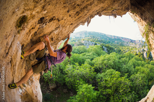 Rock climber climbs into the cave, Rock in the form of an arch