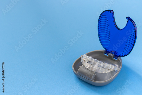 Invisalign braces or invisible retainer on blue background