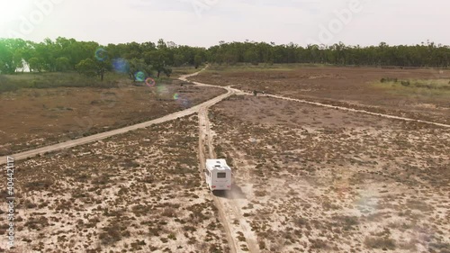 Aerial view of grey nomad driving a motorhome along dusting park roads on the way to river billabongs in the Murray Darling Basin. photo