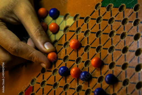 hand holding a ball while playing Chinese checkerboard game photo