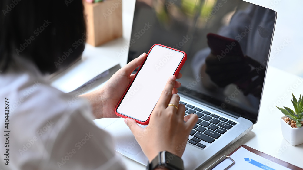 Close up view businesswoman using smartphone during take a break at her workspace. Close up view businesswoman using smartphone during take a break at her workspace.