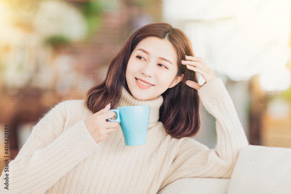 young Woman drinks coffee and relax on sofa at home young Woman drinks coffee and relax on sofa at home