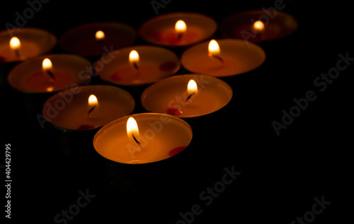 The candle flame is approaching the dark background in the night. 
