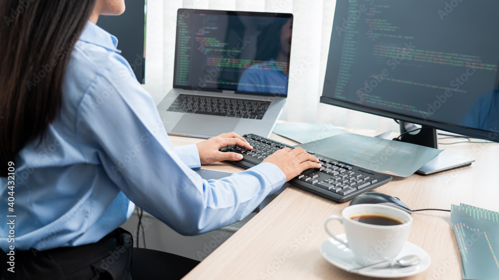 Asian woman programmer typing source code with computer pc for Developing program or application in her office. Asian woman programmer typing source code with computer pc for Developing program or application in her office.