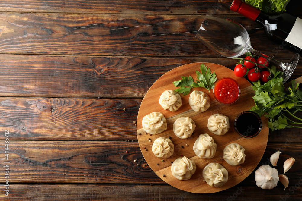 Concept of tasty lunch with board of khinkali on wooden background Concept of tasty lunch with board of khinkali on wooden background