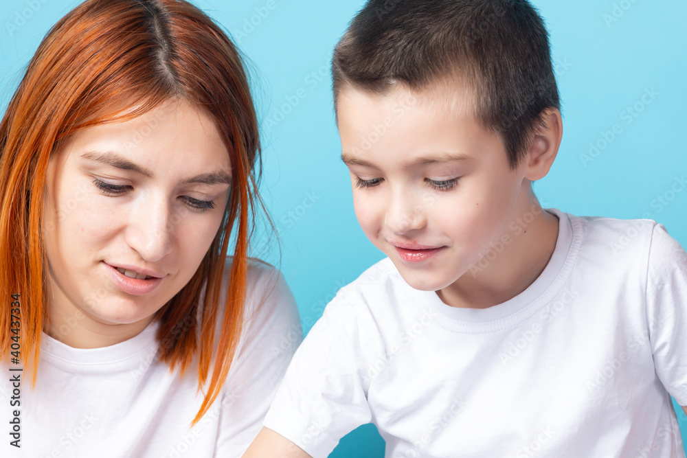 Close-up mom with her son doing homework on a blue background. Home education Close-up mom with her son doing homework on a blue background. Home education
