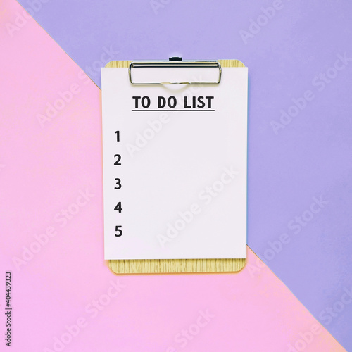 Flat lay of to do list clipboard on pastel color background, minimal style, planning and motivation concept photo