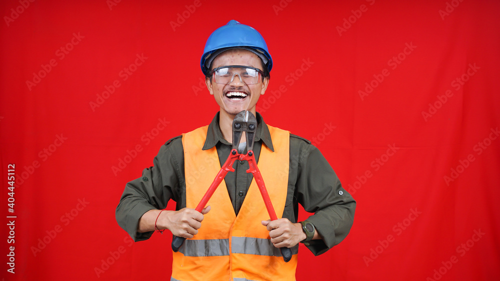 asian construction worker man wearing uniform, helmet, with cutter isolated red backgroubd asian construction worker man wearing uniform, helmet, with cutter isolated red backgroubd