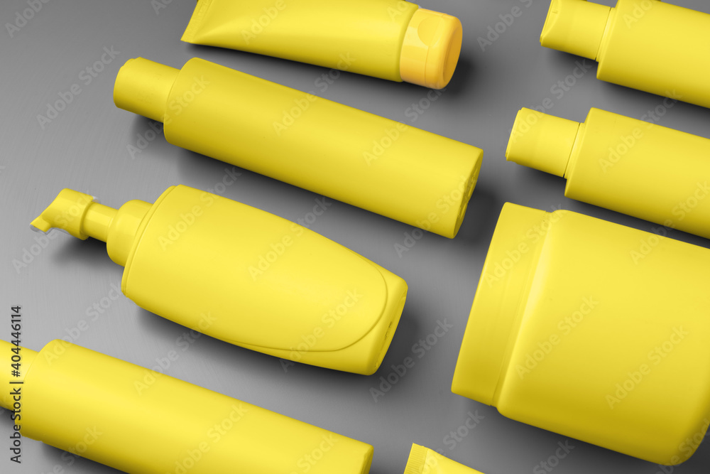 Yellow cosmetic container on gray background top view Yellow cosmetic container on gray background top view