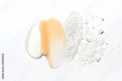 Obraz na płótnie Mix of textures of cream, lotion, liquid gel and sea salt on a white background close-up. Mixed samples of beauty products. Smeared makeup, sprinkled salt, concealer and foundation smears. w salonie