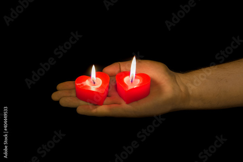 Heart shaped candles on black background