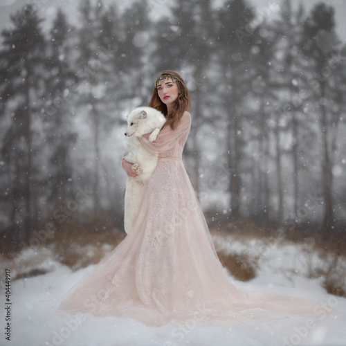 Art photo of a girl in a cream dress with a polar fox in her hands