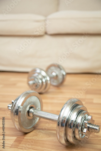 home workout weight training with dumbbell concept and couch background.