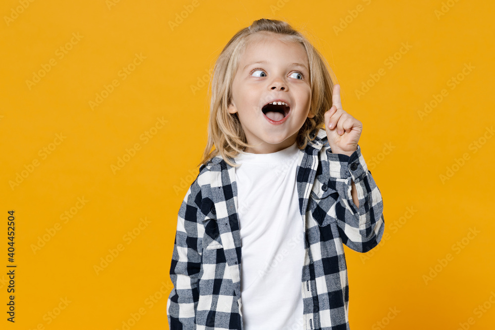 Little cute fun happy blond long-haired kid boy 5 years old wearing casual clothes posing isolated on bright yellow wall color background children studio portrait. People childhood lifestyle concept Little cute fun happy blond long-haired kid boy 5 years old wearing casual clothes posing isolated on bright yellow wall color background children studio portrait. People childhood lifestyle concept