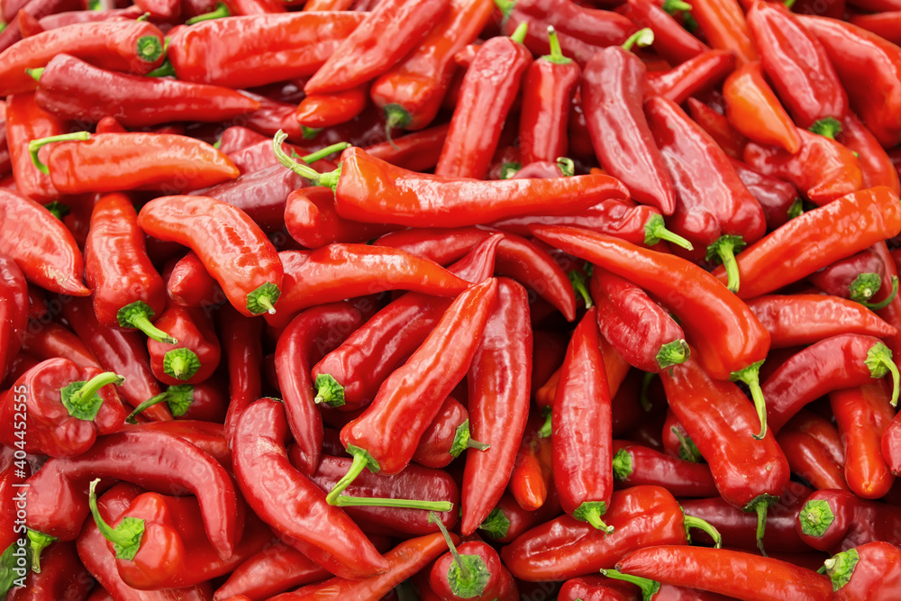 Heap of fresh red chili peppers at a market as a background